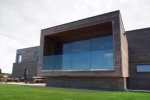 Modern home with expansive aluminium sliding doors and glazing showcasing light-filled contemporary architecture and countryside views.