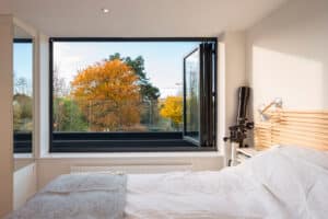 This bifold window allows the master bedroom in a loft conversion to enjoy stunning views over the roof tops of Cambridge