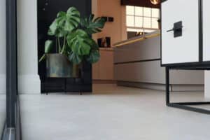 Modern kitchen interior featuring slide and turn doors, alongside a white cabinet, a large green potted plant, and warm ambient lighting.