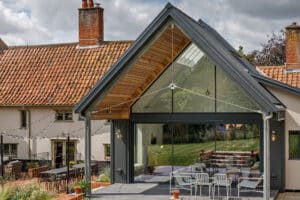 Period timber framed house with modern zinc clad extension featuring theEDGE2.0 sliding doors