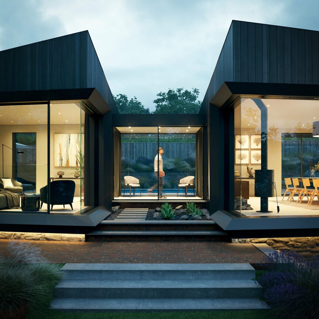 Modern house with large glass windows showing interior rooms; a person is walking inside a glass corridor connecting two sections.