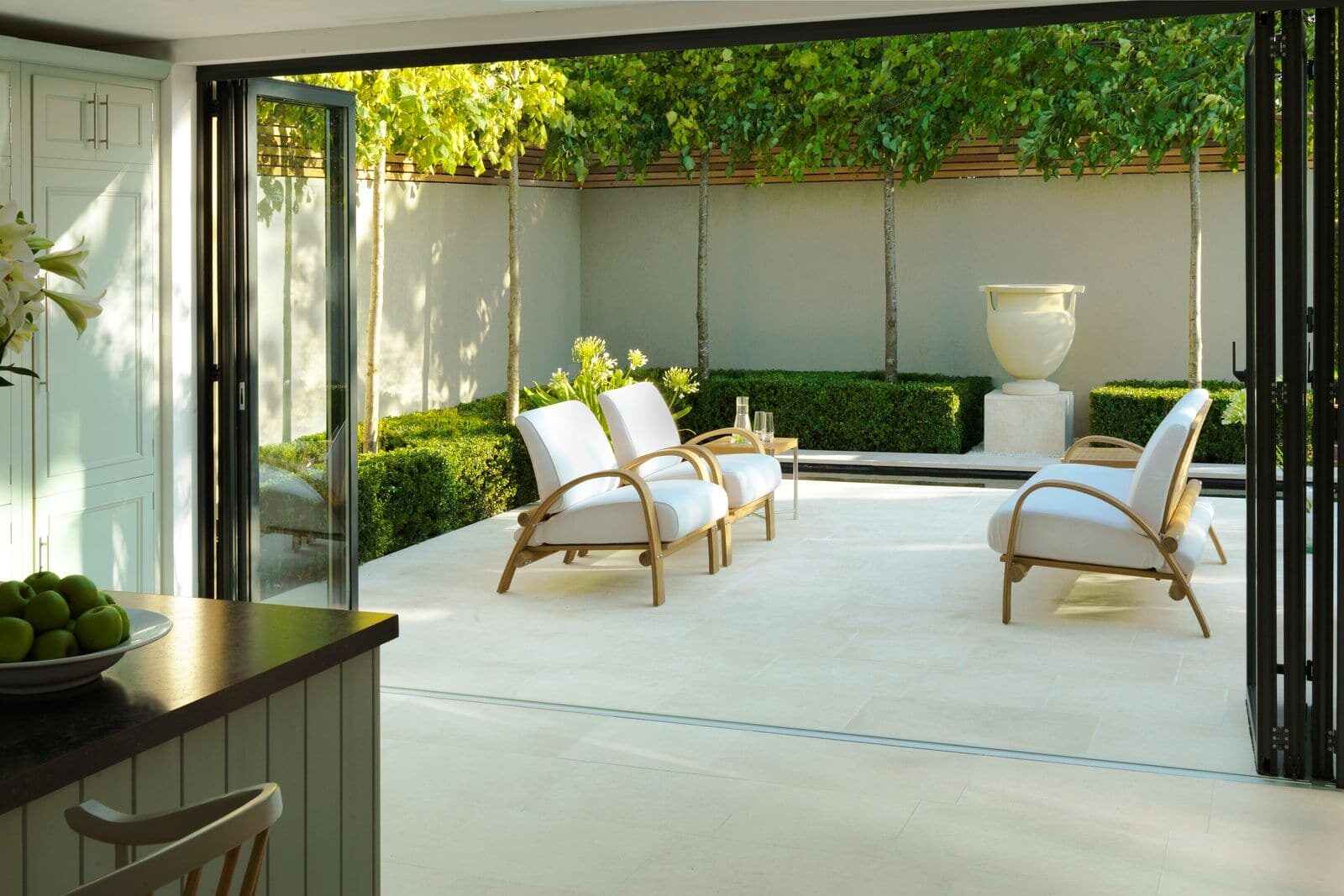 Modern aluminium sliding doors opening onto a garden patio, showcasing seamless indoor-outdoor living with floor-to-ceiling glazing