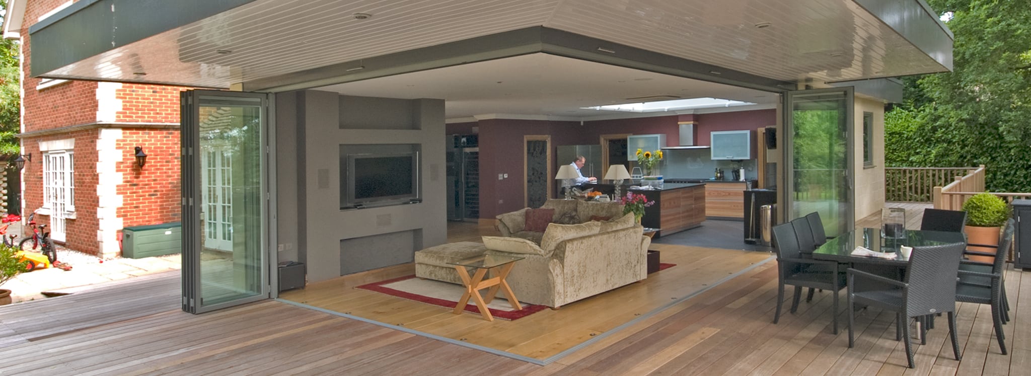 Modern home with open-plan living space framed by bifold doors, seamlessly connecting interior to exterior patio area.